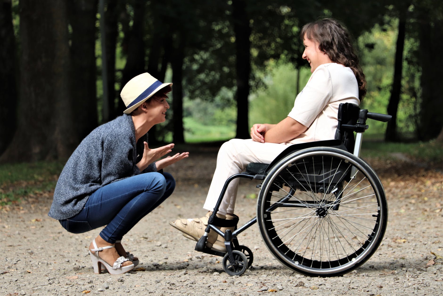 Eine Frau die im Rollstuhl sitzt redet mit einer anderen Frau